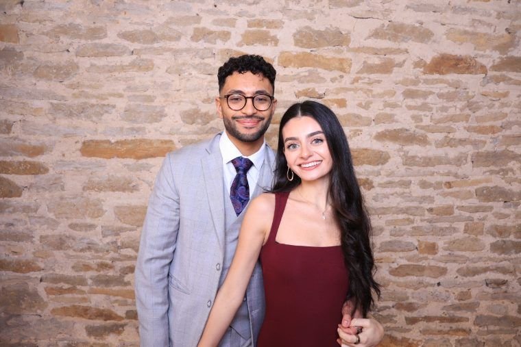 A couple posing together at the K&A booth's brick-wall backdrop